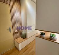An entrance hall with wooden floor decor and wall cladding in a 3-room apartment.