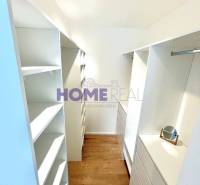 A wardrobe in a 3-room apartment with storage spaces and flooring with a wood decor.