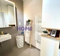 Bathroom with a sink, mirror, and white radiator in a 3-room apartment.