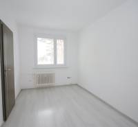 A room with a window, a radiator, and a wooden decor floor in a 3-room apartment.