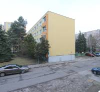 Apartment building in Bratislava on Cabanova Street in an environment with coniferous trees.