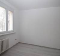 A room with white walls and a wooden decor floor in a 3-room apartment.