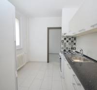 A kitchen in a 3-room apartment with tiled flooring, patterned tiles near the stove.