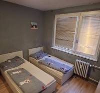 Children's room in a 3-room apartment with two beds and a floor with a wooden decor.