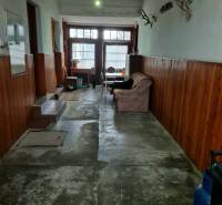 A hallway in a family house with simple furniture, a wall with wood paneling, and hunting trophies.