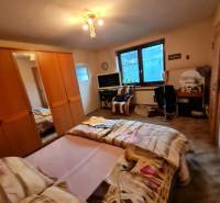 Bedroom with a bed, wardrobe, and desk in a family house.