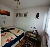 A bedroom in a family house with a wooden decor floor, pictures, and decorative items.