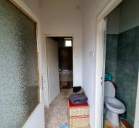 Bathroom and toilet with tiles in a family house, with a storage basket.