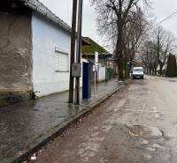 A family house on Komenského Street in Šurany, by the road with an electric pole and trees.