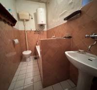 A bathroom in a family house with a gas boiler and ceramic tiles.