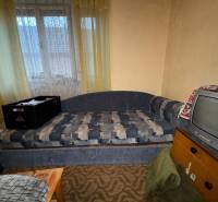A sofa and a television in the living room of a family house with vintage interior decoration.