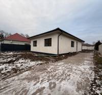 A family house in Senec with an unmaintained snow-covered plot and a concrete walkway.