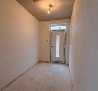 A hallway in a family house with simple lighting and plastic doors.