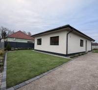 A family house in Veľký Grob with a lawn, gravel path, and landscaped garden.