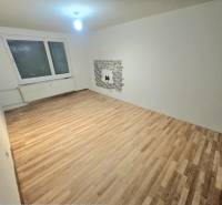 Living room with wood-patterned flooring and a window in a 3-room apartment.