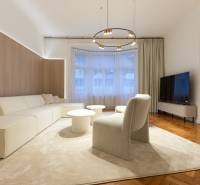 Elegant living room with a light sofa, round tables, and a floor with a wood decor.