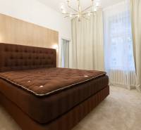 A bedroom in a 3-room apartment with curtains, an upholstered bed, and a pendant light.