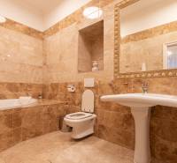 Bathroom with a mirror, sink, and bathtub. Tiles in earthy tones complement the interior decoration.