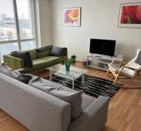 Bright living room with sofas, an armchair, and a television in a 2-room apartment.