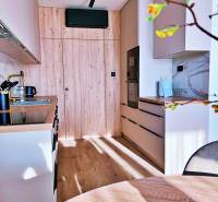 A kitchen in a 3-room apartment with a wooden decor and built-in appliances.