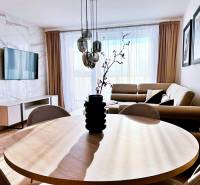 Living room in a three-room apartment with a wooden decor floor and a comfortable sofa.