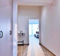 A bright hallway in a 3-room apartment with wood-decor flooring and built-in wardrobes.