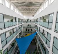 An interior atrium with transparent glass railings and colorful sails.