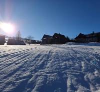 Snow-covered residential plots in Ždiar with an impressive snow-covered hill.