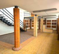 Two-story commercial spaces with wood-patterned flooring and a staircase.