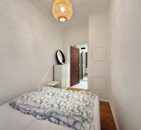 Bedroom with a bed and wooden decor flooring in a two-room apartment.