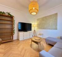 Living room in a two-room apartment with a wooden decor floor and a comfortable sofa.