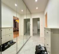 Hallway with a large built-in wardrobe and shoe cabinet in a 2-room apartment with tiled flooring.