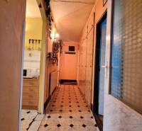 A cozy hallway with an entrance to the kitchen and tiles in a 3-room apartment.
