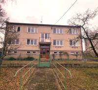 An apartment building in Kuklov with a front garden and a staircase leading to the entrance door.