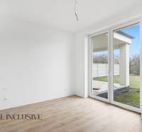 A room in a family house with a large window and a wooden decor floor.