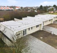 A family house in Čukárska Paka in Veľká Paka with a flat roof and paved parking.