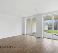 A room in a family house with a wooden decor floor and French windows.