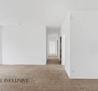 A white hallway in a family house with a wooden decor floor and glass doors to the yard.