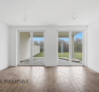 In the family house, there is a spacious room with large windows and a floor with a wooden decor.