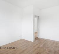 White room with wood-patterned flooring in a family house.