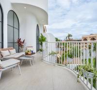 Spacious balcony in a villa with comfortable seating, plants, and a view of Berawa in Canggu.