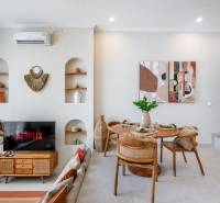 Living room of the villa with a TV, dining table, and decorative elements on the walls.