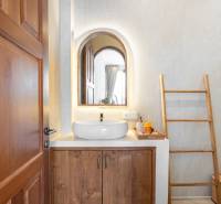 A bathroom in a villa with a mirror, a sink, and a ladder as decoration.