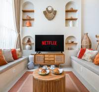 A comfortable living room in a villa with a television, cushions, and decorations, coffee is being served.