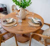 Dining table in a villa with wooden decor, seating and set plates.