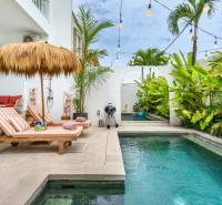 Villa in Canggu on Berawa Street, pool with loungers and tropical greenery.