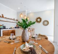 A table set in a villa with a wooden floor decor and a kitchenette.