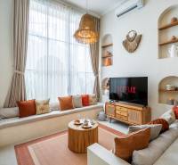 Bright living space in the villa with a sofa, TV, and decorative lighting.