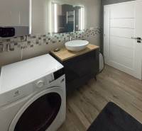 Bathroom with a washing machine and a sink in a 3-room apartment, small mosaic on the wall.