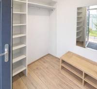 A hallway with shelves and a wooden decor floor in a 3-room apartment.
